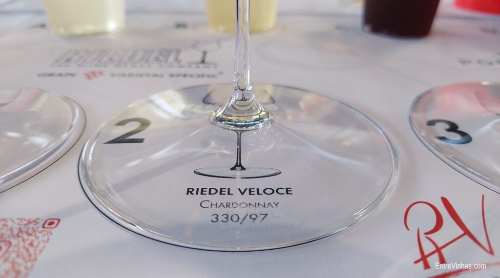 Detalhe de identificação de copo de vinho na sua base. Pode ler-se Riedel Veloce Chardonnay 330/97